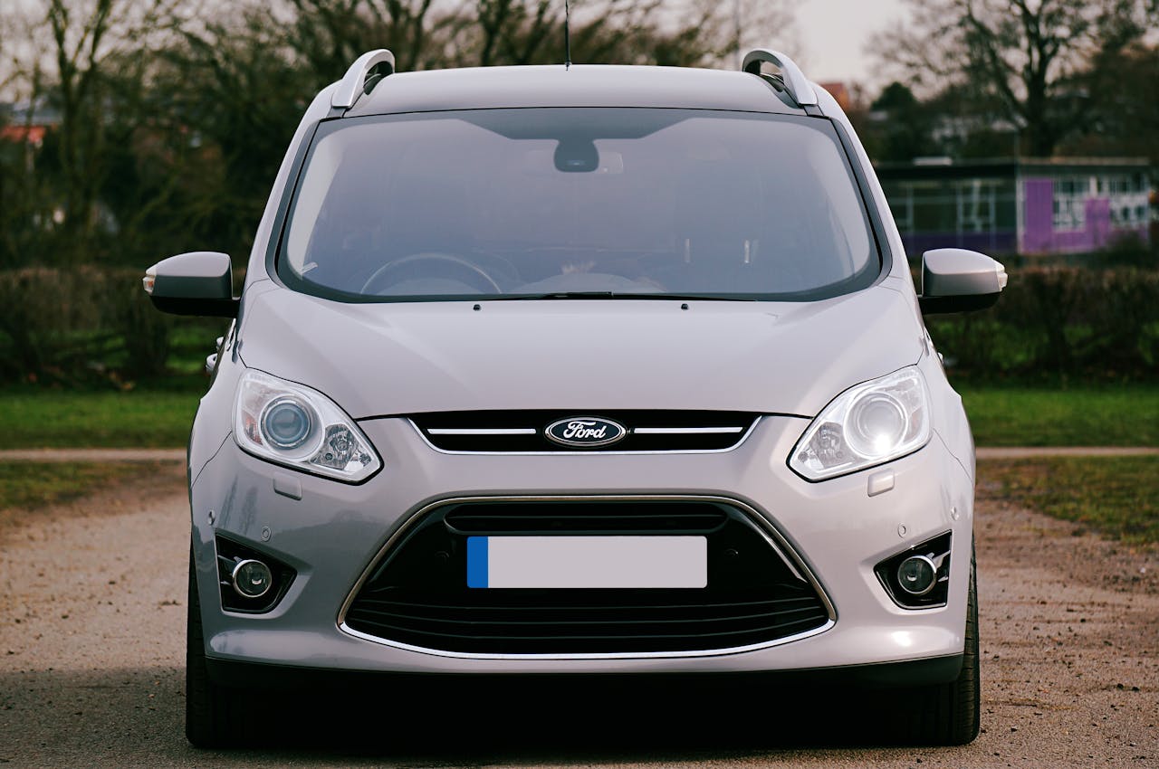 Home Silver Ford car parked on a dirt road surrounded by trees in the UK.
